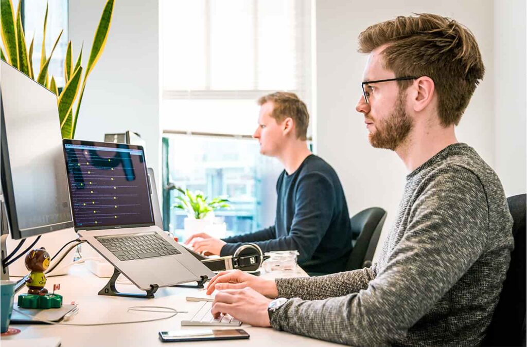 Seorang backend developer sedang bekerja di depan komputer.