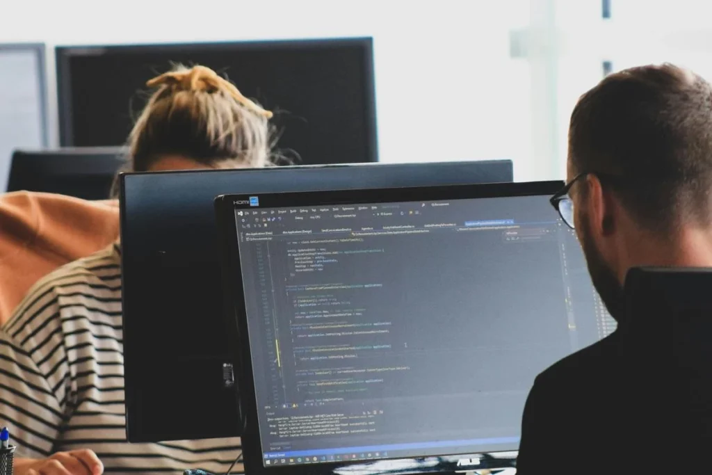 Definisi IaaS: Contoh dan Perbedaannya dengan PaaS & SaaS man and woman in front of computer