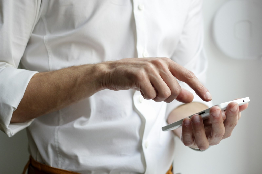 Pasien memegang ponsel untuk mengambil nomor antrean online