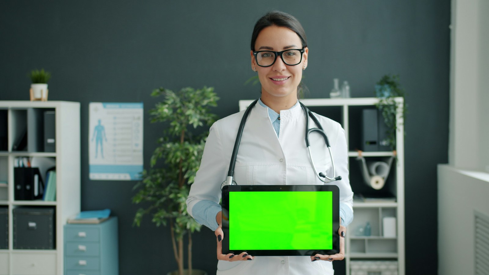 Dokter memegang tablet untuk mengakses data pasien dari sistem informasi rumah sakit