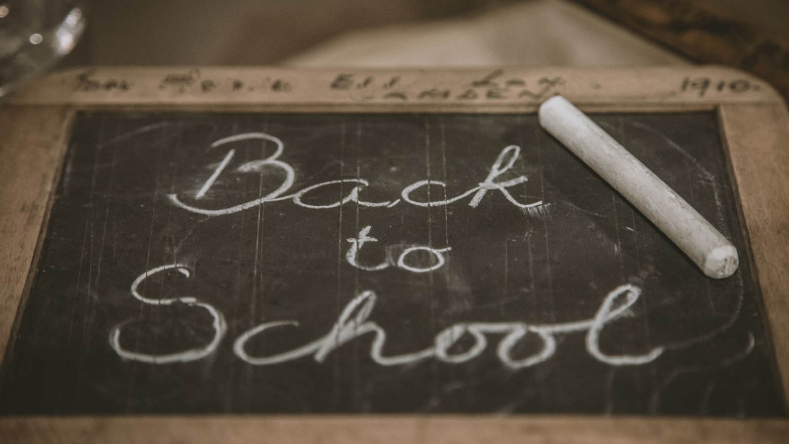 Papan tulis kecil bertuliskan Back to School dengan sepotong kapur