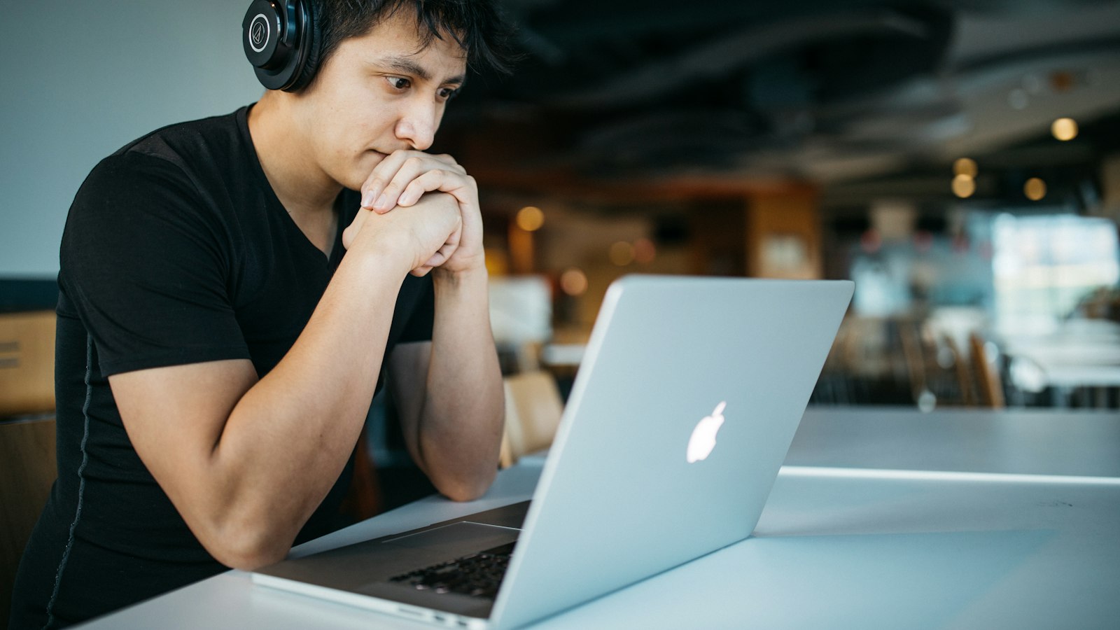 Cara Membuat LMS Sendiri: Jalur, Fitur Inti, Standar SCORM dan xAPI, serta Tahapannya Pengembang bekerja memakai headphone di depan laptop