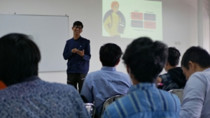 Pelatih berdiri di depan sekelompok peserta pelatihan
