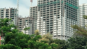 Deretan apartemen bertingkat yang sedang dibangun di antara pepohonan hijau