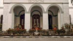 Bagian depan gedung putih bergaya kolonial bertuliskan BOGOR 1881