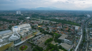 Pemandangan udara kawasan perkotaan dengan pusat perbelanjaan Margo City dan jalan raya yang padat