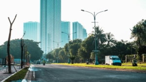 Jalan lebar dengan deretan gedung kaca yang tinggi di kawasan kota