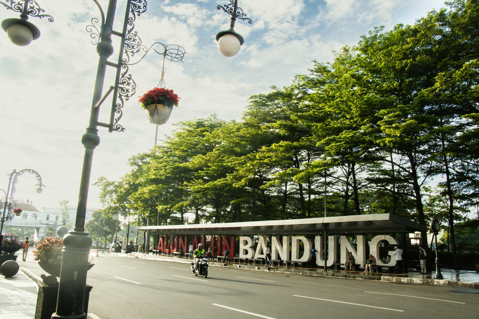 Tulisan Alun-Alun Bandung di tepi jalan yang dinaungi pepohonan