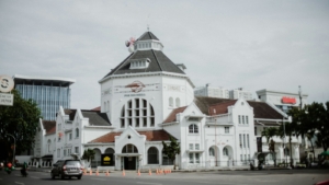 Gedung putih bergaya kolonial dengan menara di tepi jalan