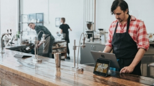 Barista memakai tablet kasir di kedai kopi